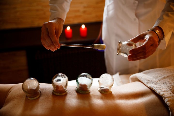 Glass cups on a person's back