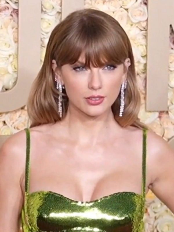 Taylor Swift in a green dress on a red carpet