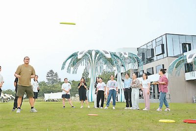 草地上一群人在玩飞盘